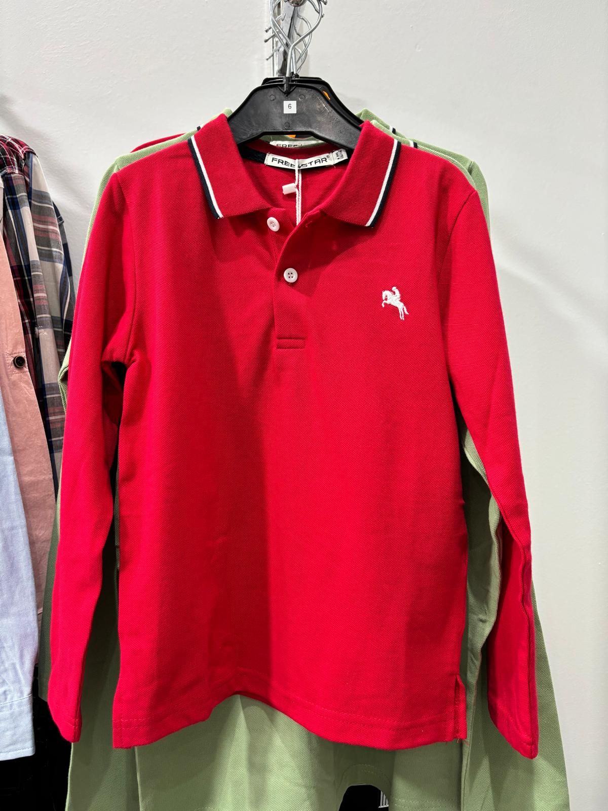 Un polo rojo con un caballo blanco bordado en él.