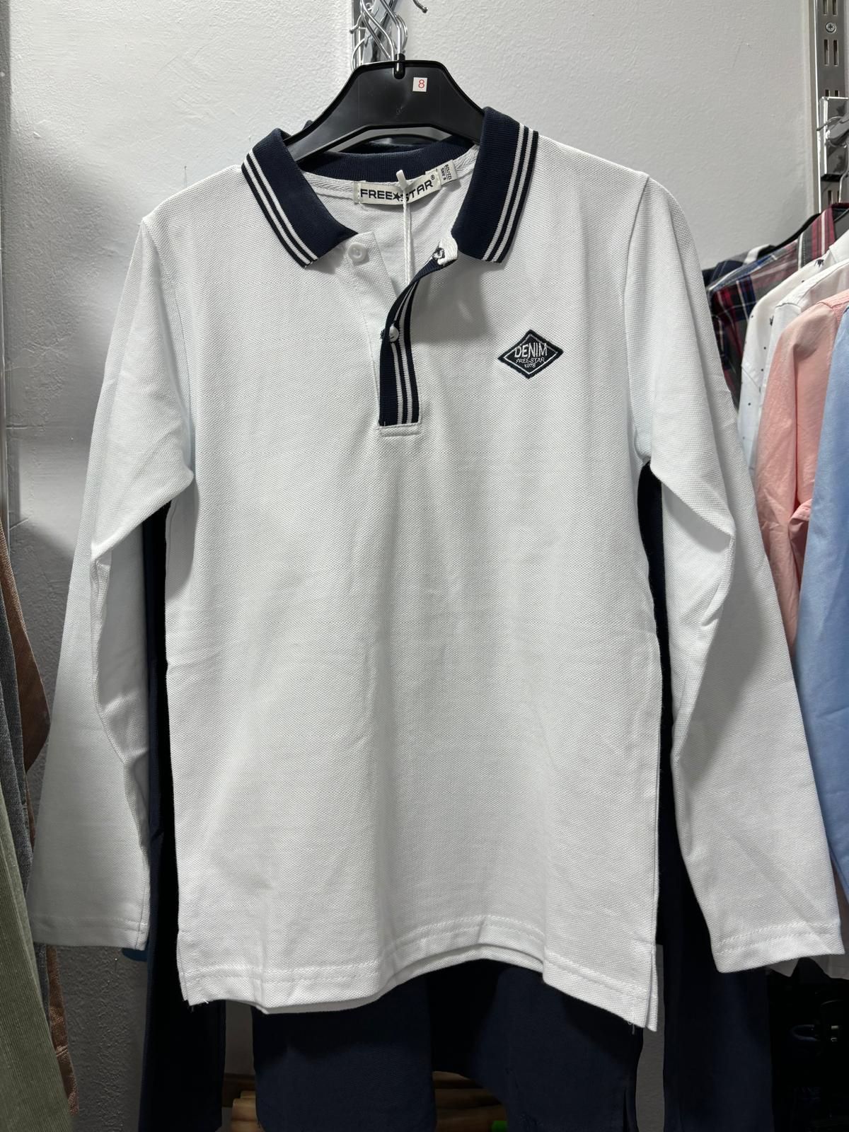 Una camisa polo blanca con cuello negro está colgada en un perchero.