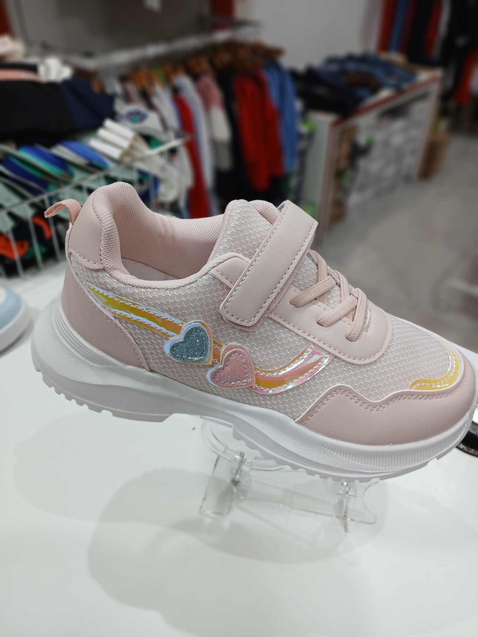 Un par de zapatillas rosas con corazones están sobre una mesa.