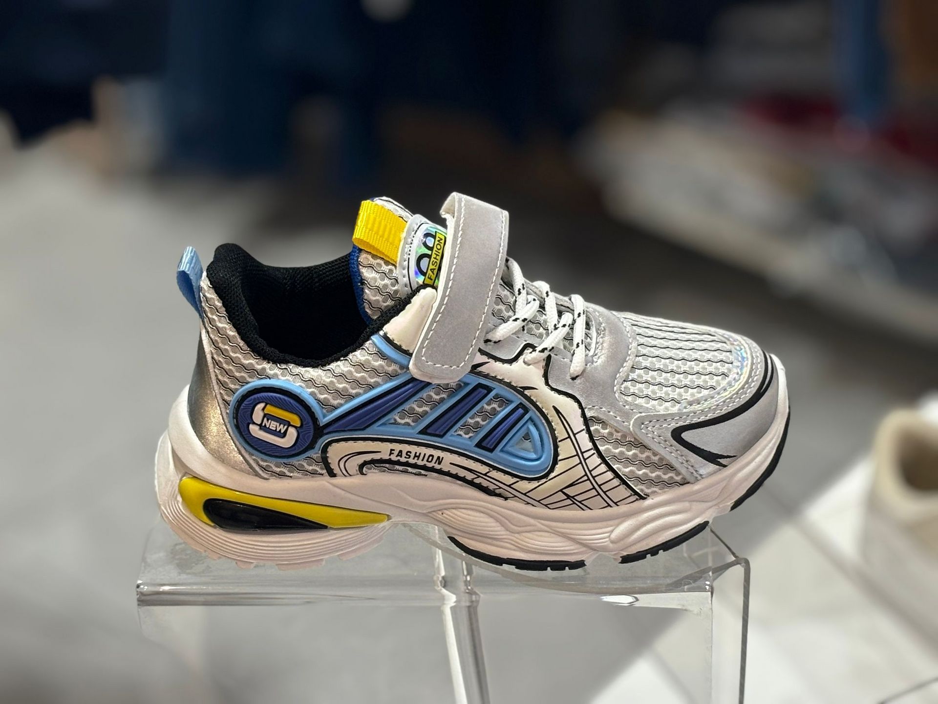 Un par de zapatillas se encuentran encima de un expositor transparente.