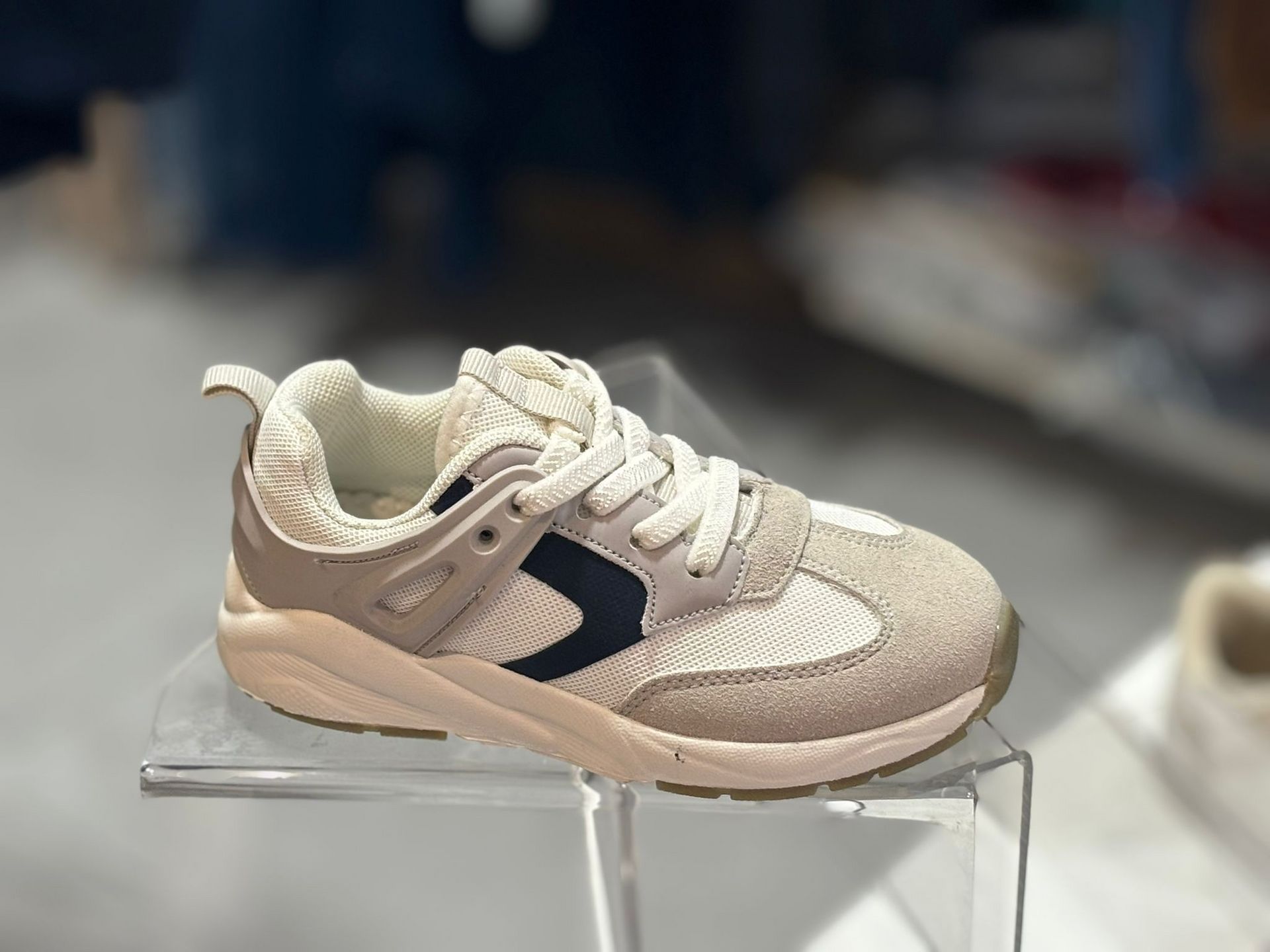 Un par de zapatillas de deporte encima de una vitrina transparente.