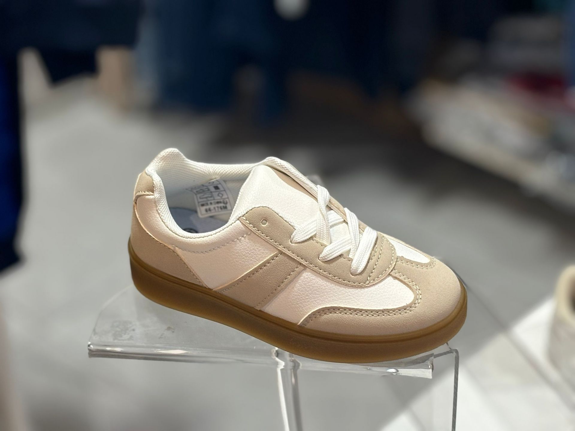 Un par de zapatillas de deporte encima de una vitrina transparente.