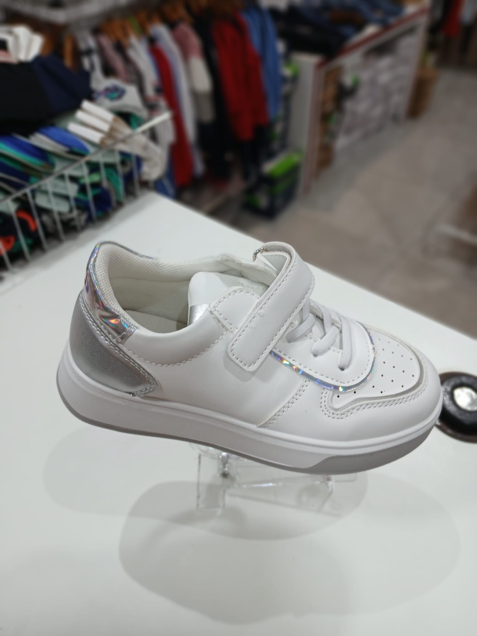 Un par de zapatillas blancas están encima de una mesa blanca.