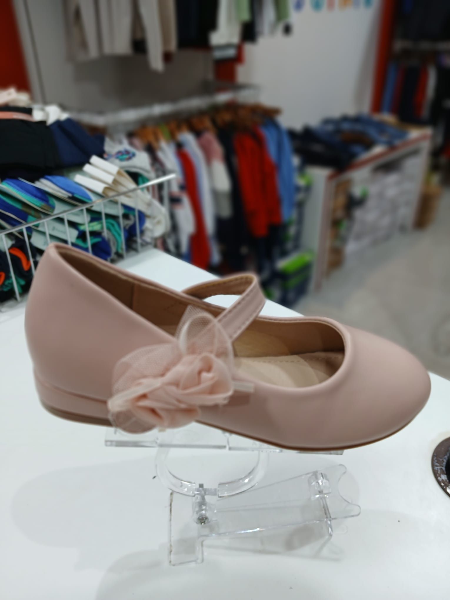 Un par de zapatos rosas con un lazo en el costado están sobre una mesa.