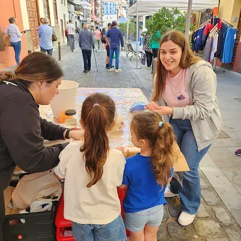 Una mujer está hablando con dos niñas pequeñas en una mesa.