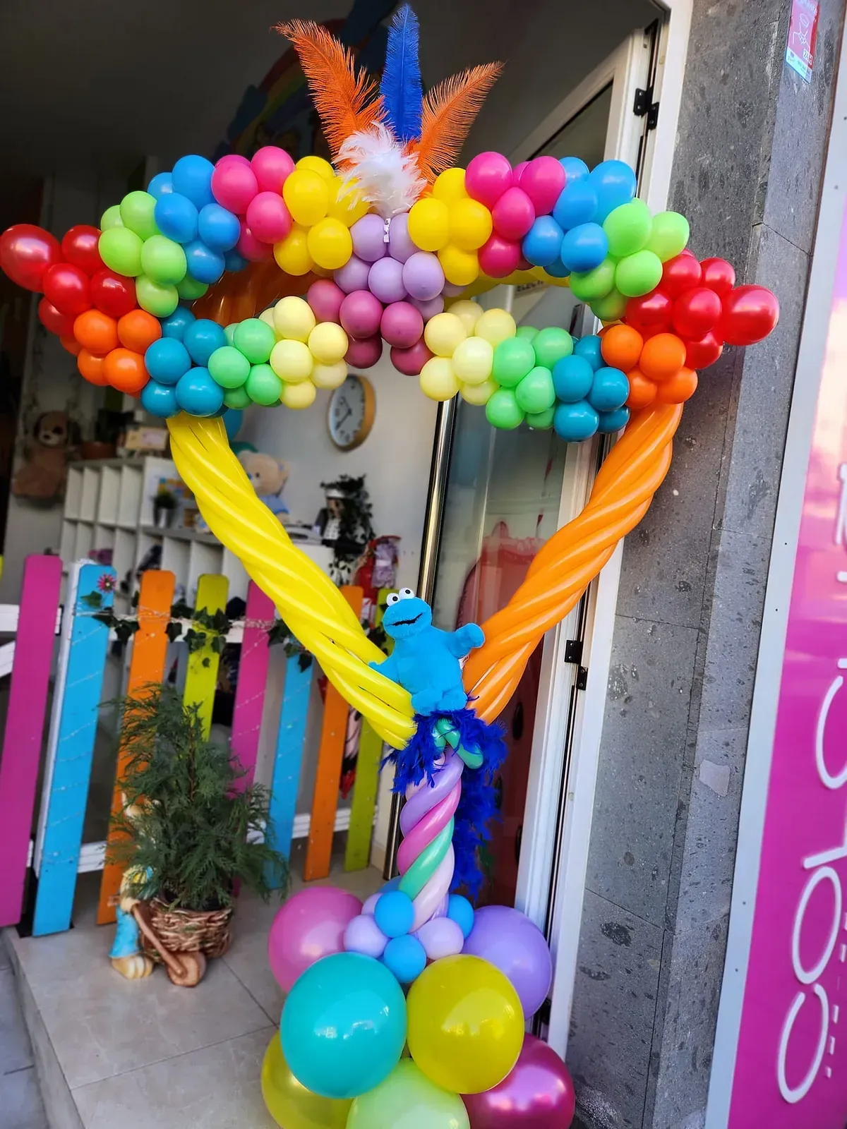 Un montón de globos de colores frente a una tienda.