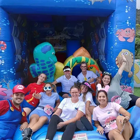 Un grupo de personas posa para una fotografía delante de un castillo inflable.