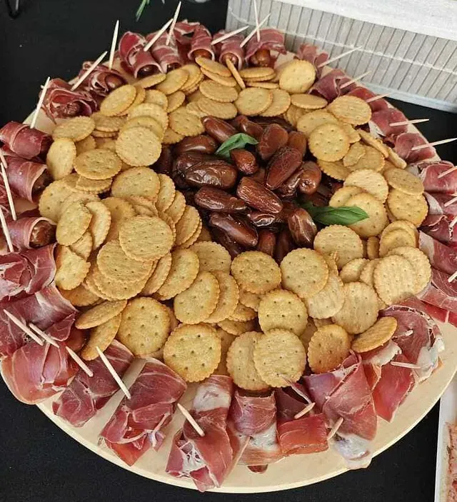 Un plato de comida con galletas y carne en palitos.