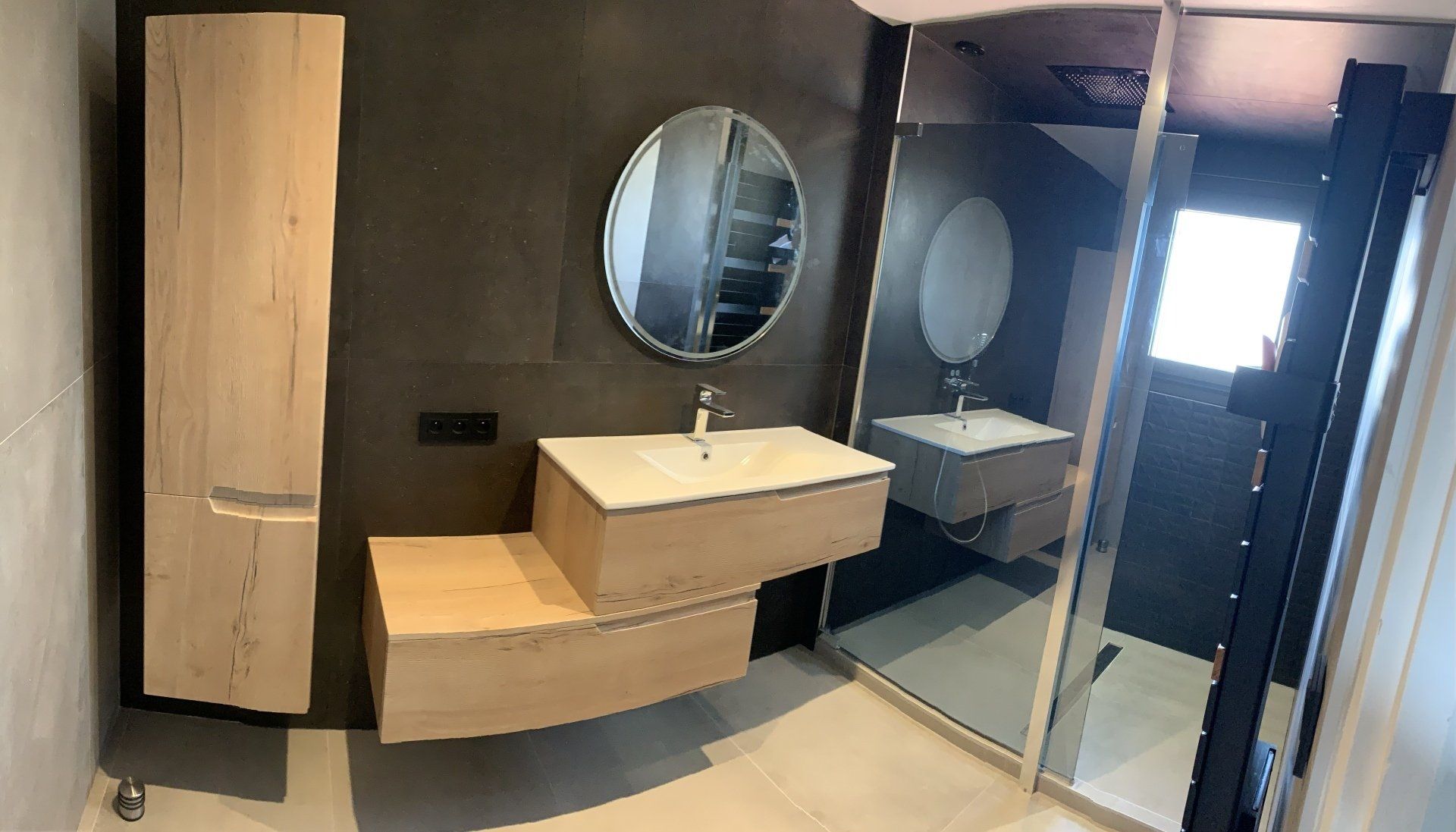Salle de bains rénovée avec un miroir rond