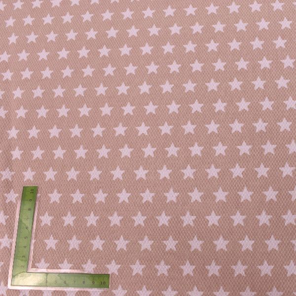 Una regla está sentada sobre un trozo de tela con estrellas blancas.