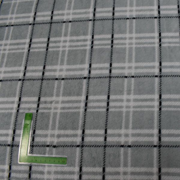 Una tela a cuadros gris y blanca con una regla verde sobre ella.