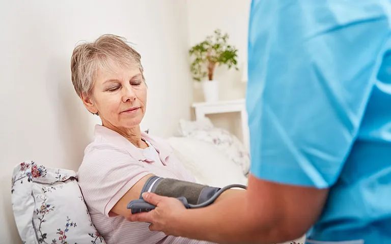 enfermero tomando presión a mujer adulta mayor