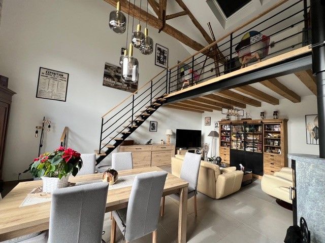 Salle à manger et salon en mezzanine avec escalier courbe, haut plafond et mobilier moderne