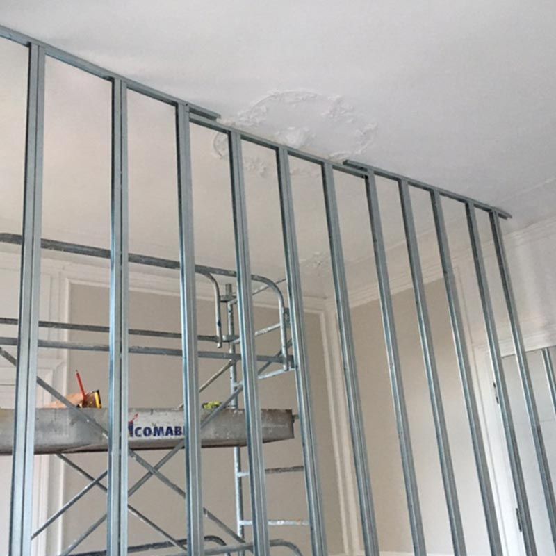 Construction d'une ossature métallique et d'un échafaudage dans une pièce dont le plafond est partiellement endommagé.