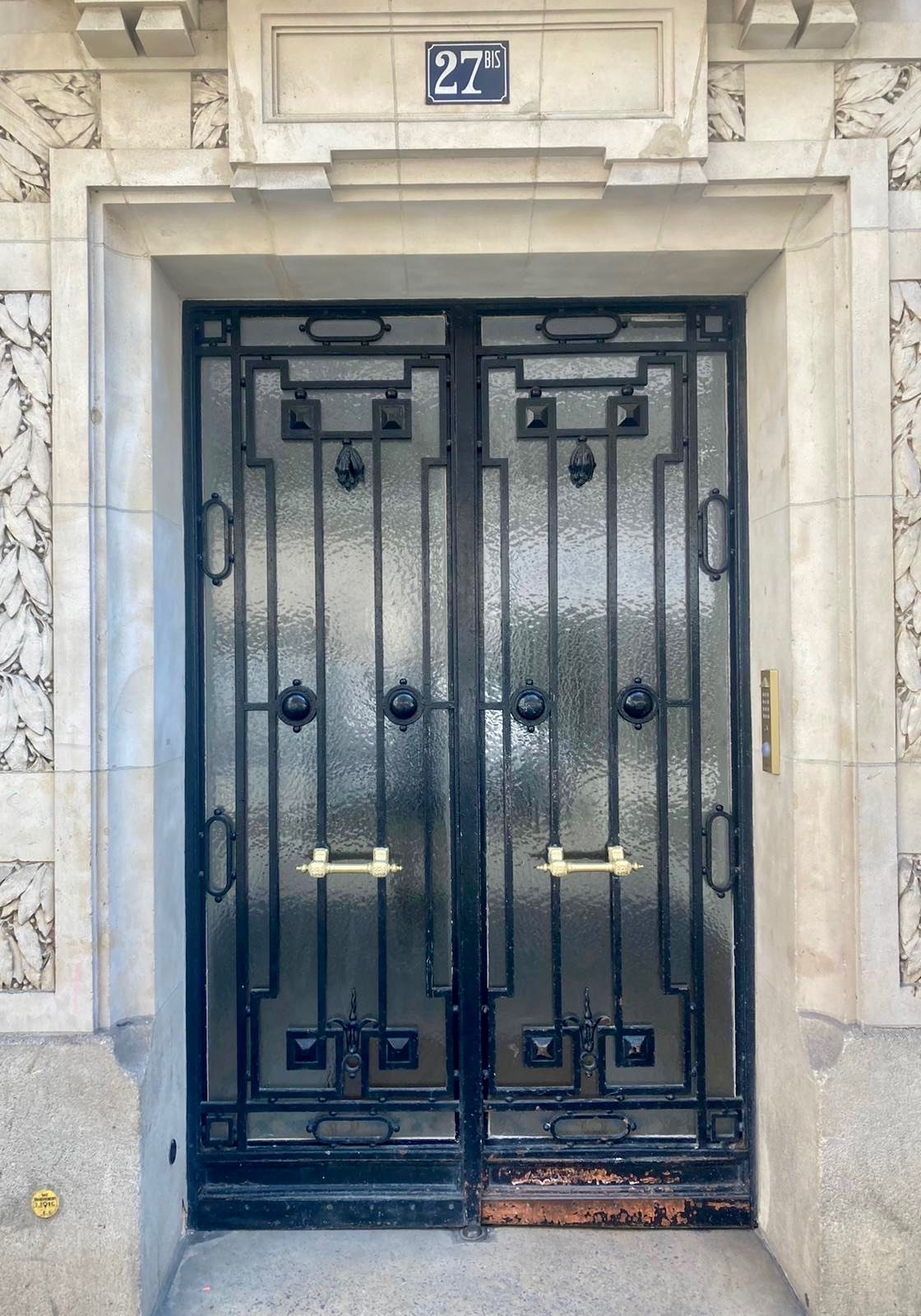 Double porte en fer noir avec panneaux de verre.