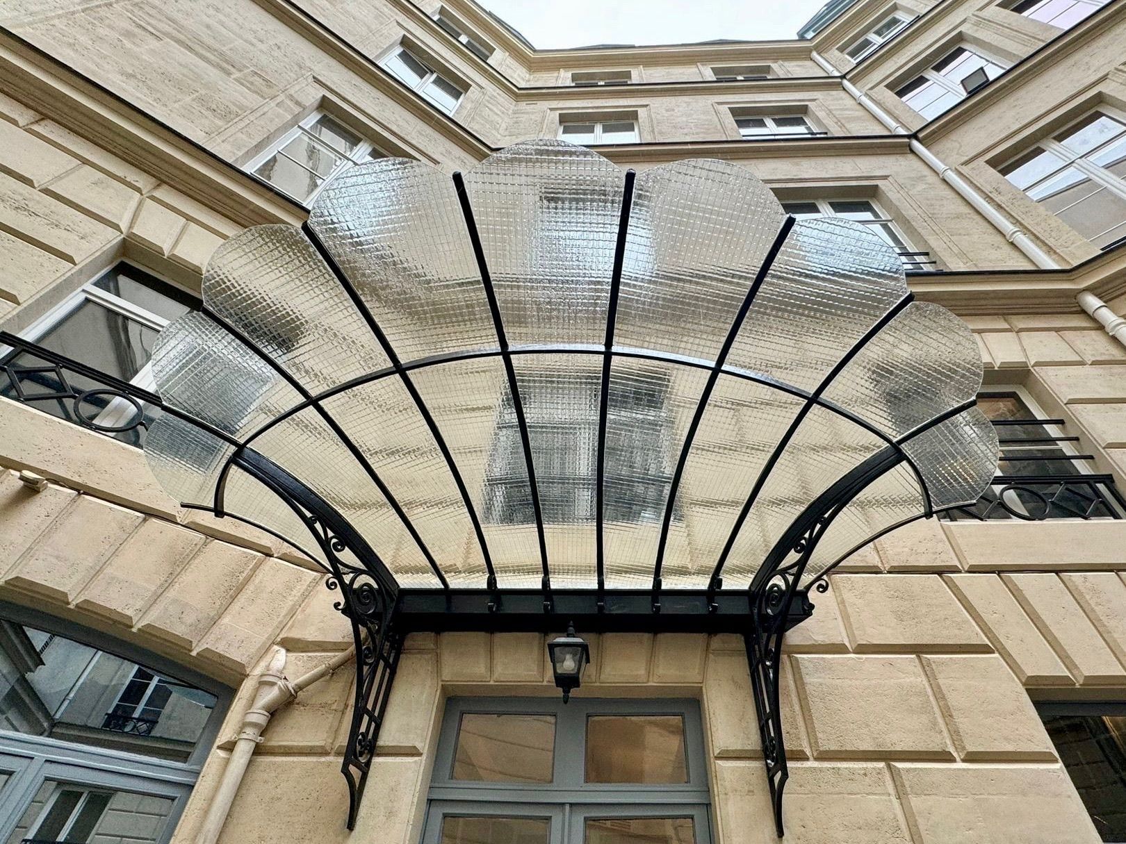 Puits de lumière avec un cadre géométrique en métal noir.