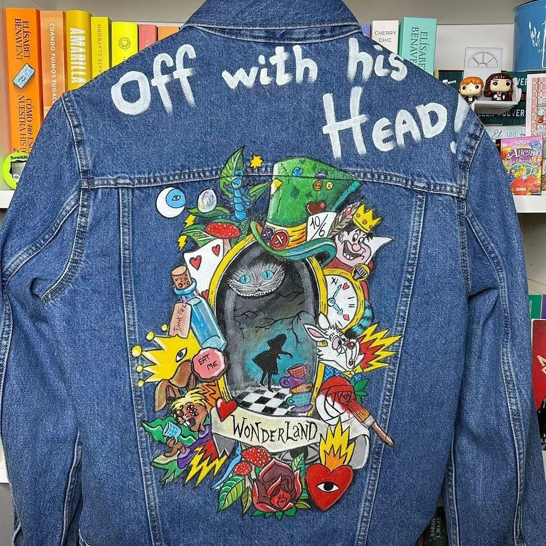Una chaqueta vaquera con una imagen de Alicia en el país de las maravillas pintada en ella.