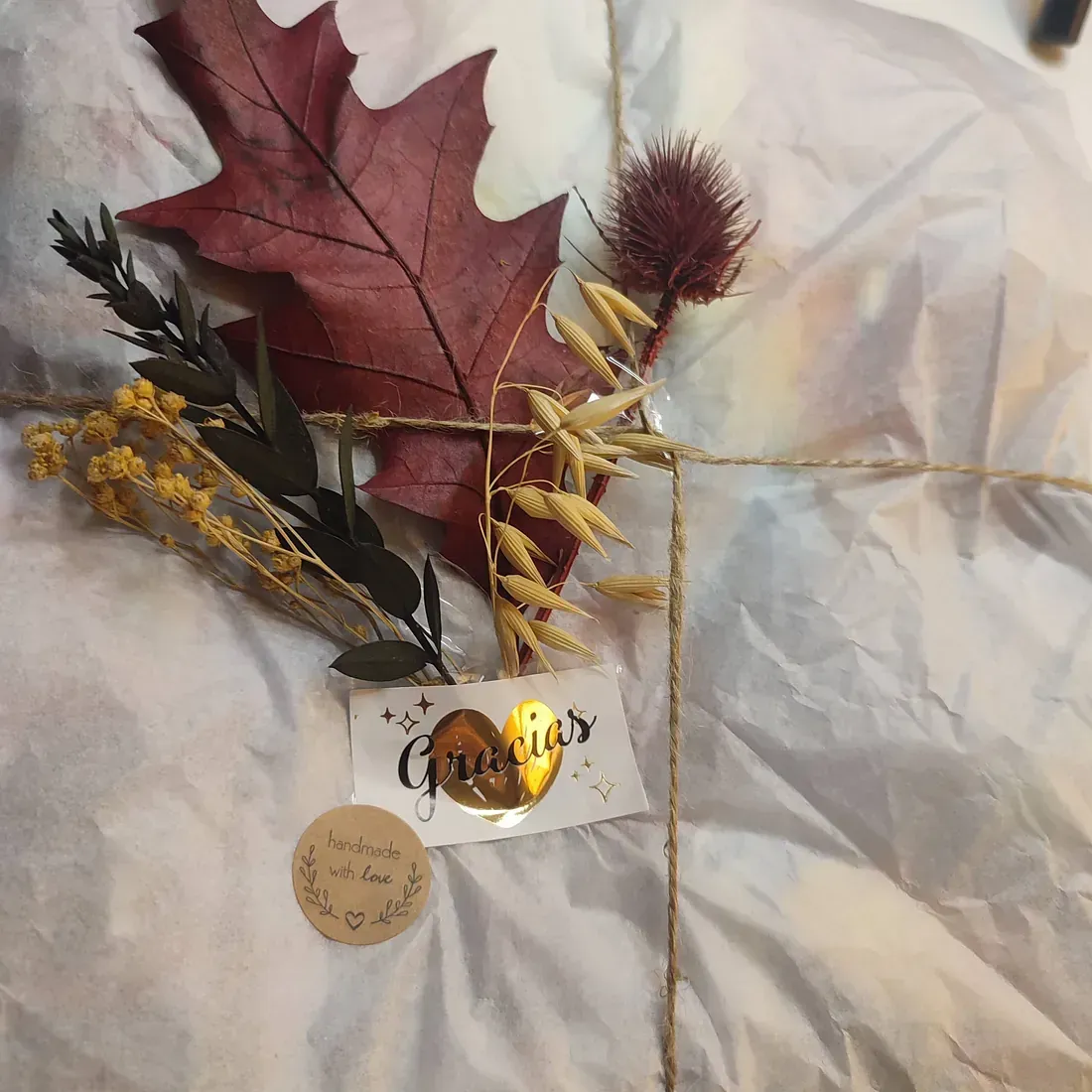 Una tarjeta con una hoja de arce y flores.