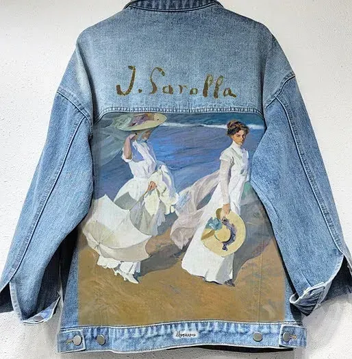 Una chaqueta vaquera con una pintura de dos mujeres en la espalda.