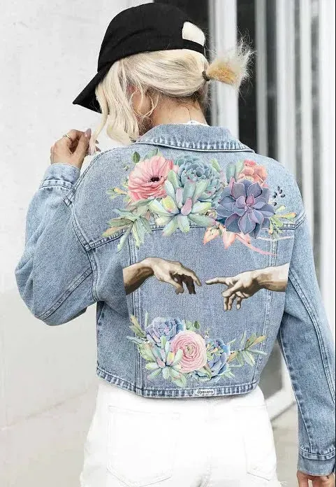 Una mujer lleva una chaqueta vaquera con flores pintadas en la espalda.