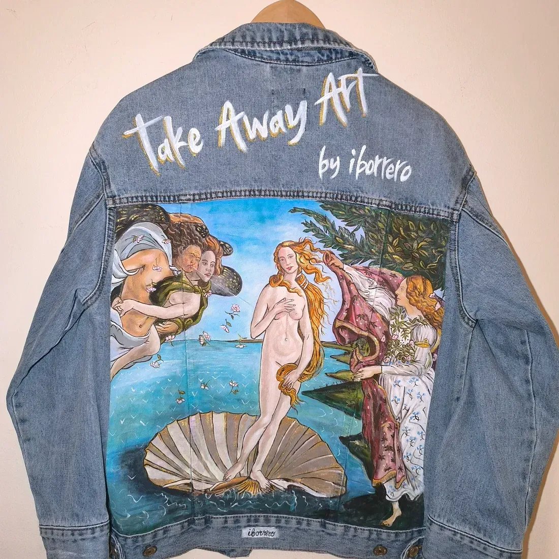 Una chaqueta vaquera con una pintura del nacimiento de Venus en la espalda.