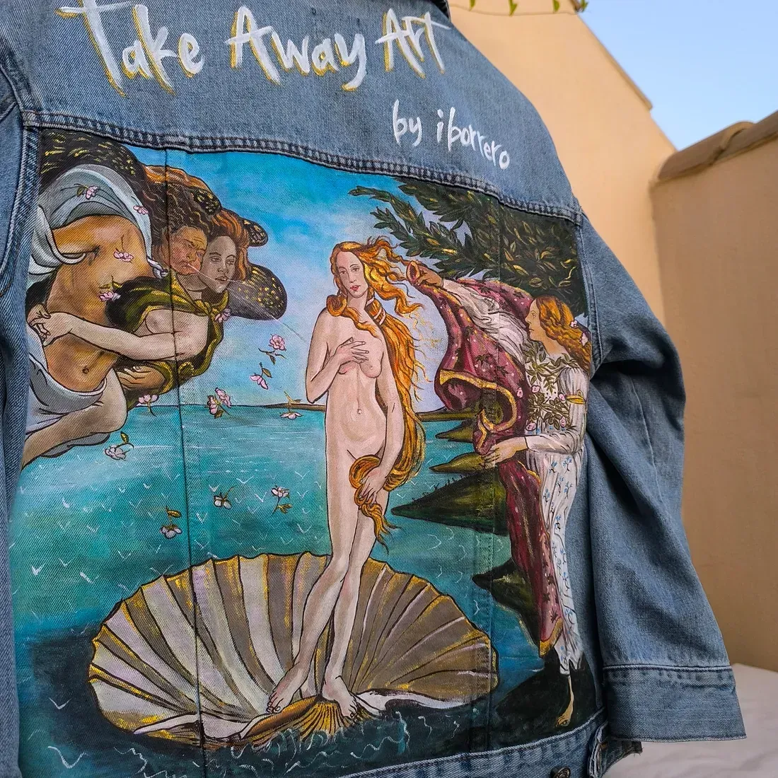 La parte trasera de una chaqueta vaquera tiene una pintura del nacimiento de Venus.