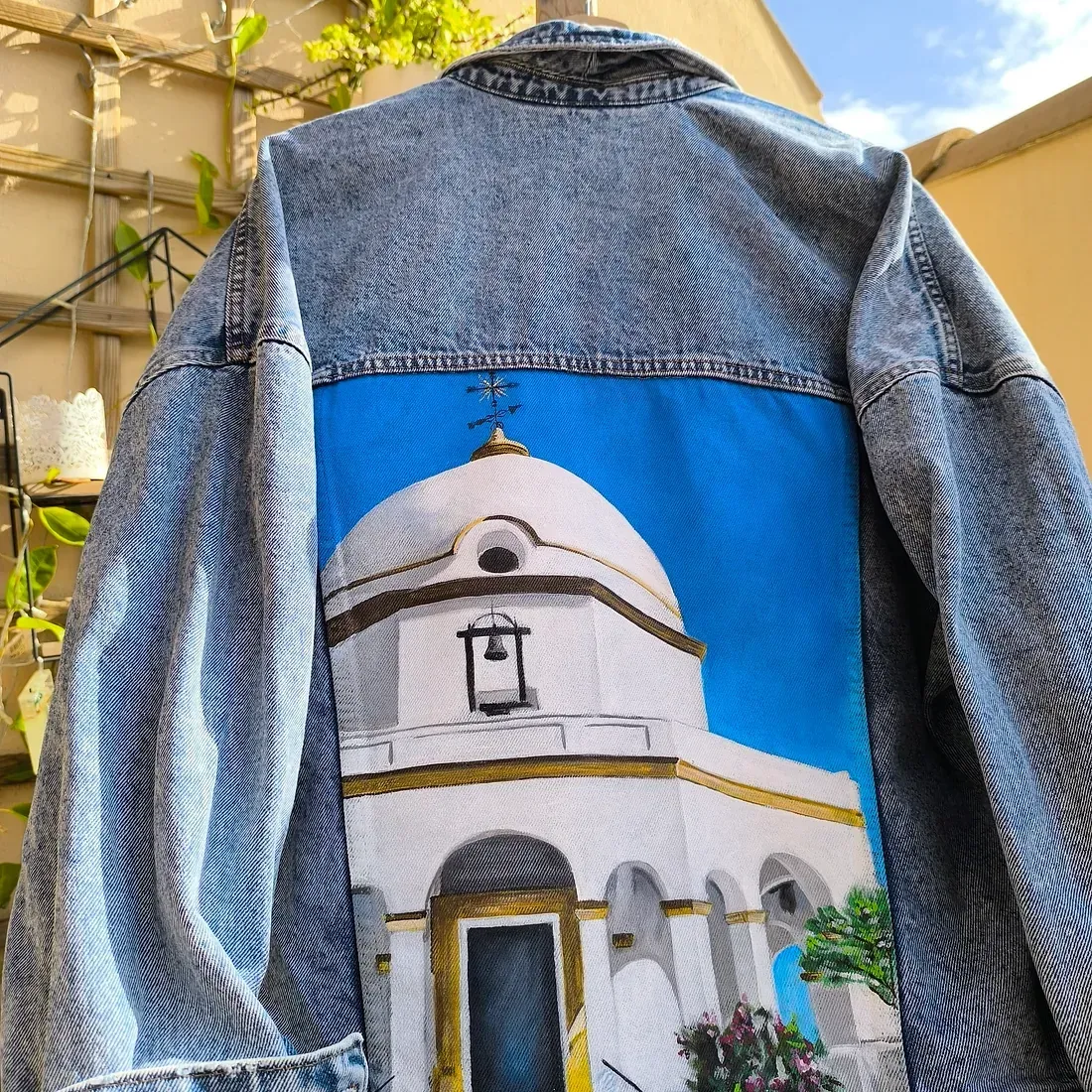 Una chaqueta vaquera con una imagen de una iglesia en la espalda.