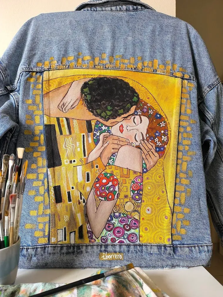 Una chaqueta vaquera con una pintura de un hombre y una mujer besándose.