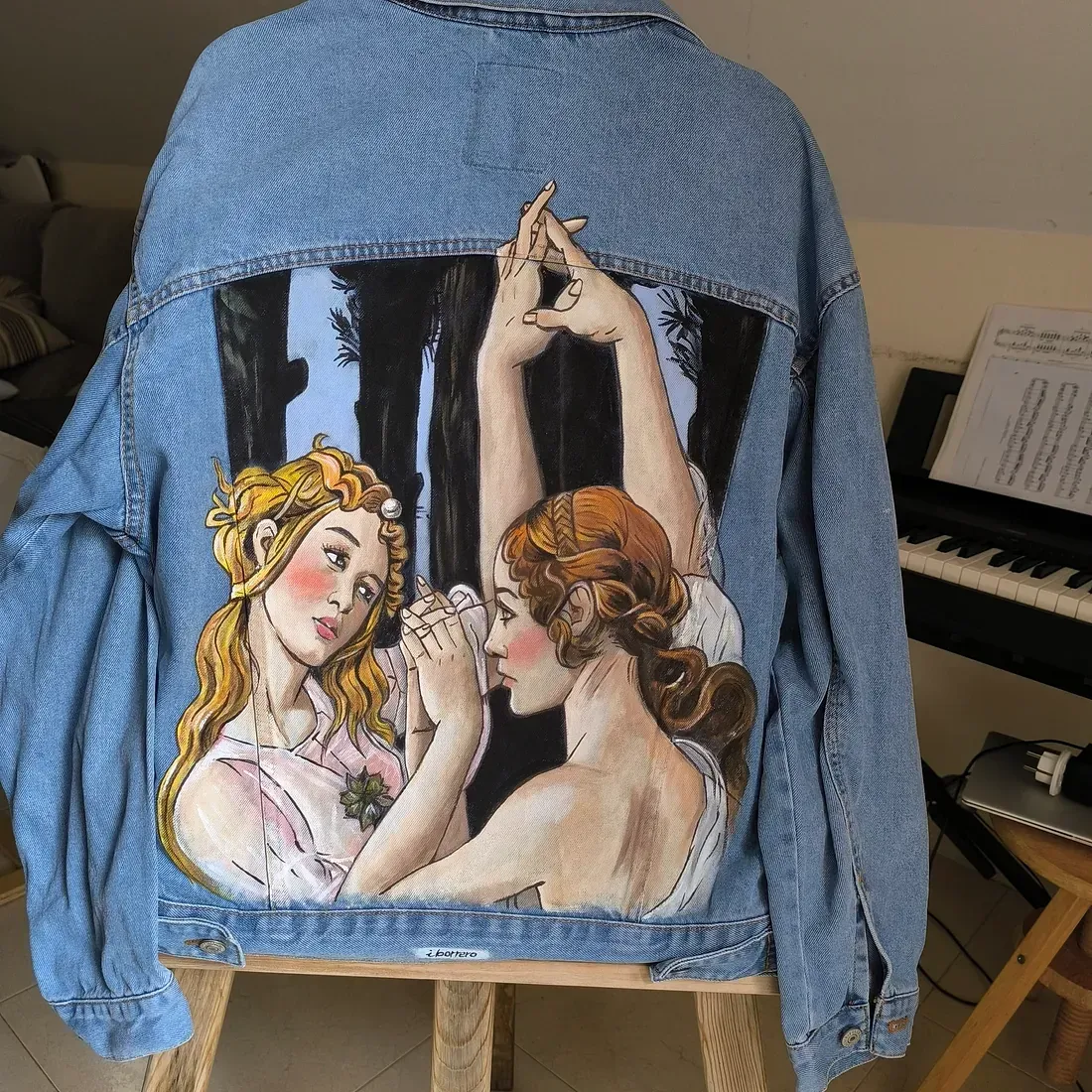 Un cuadro de dos mujeres en la parte trasera de una chaqueta vaquera.