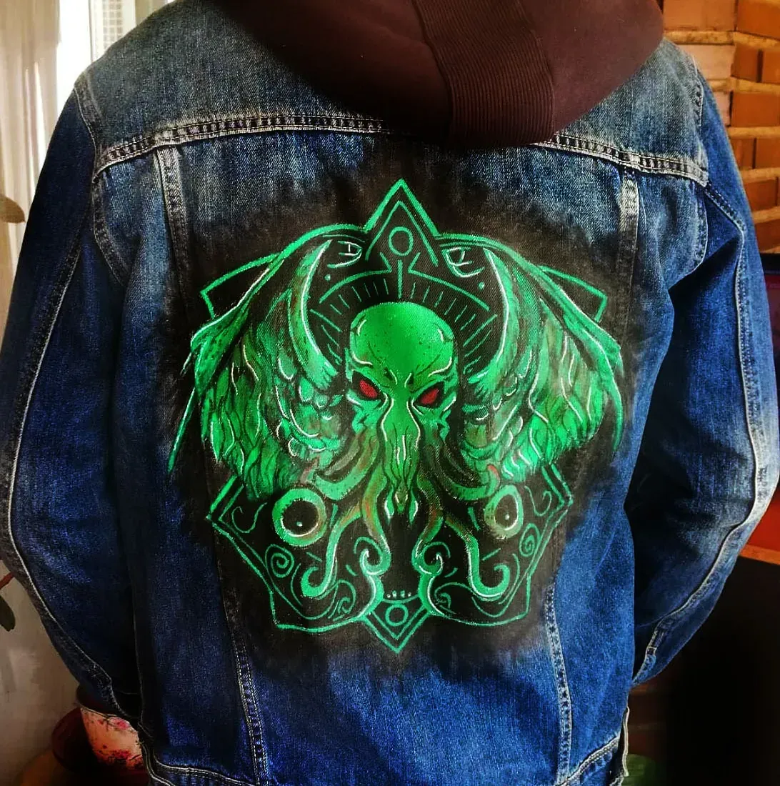 Una persona que lleva una chaqueta vaquera con un pulpo verde en la espalda