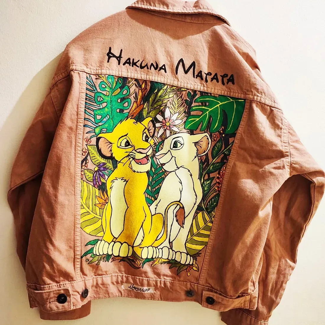 Una chaqueta vaquera con una imagen de Simba y Nala en la espalda.