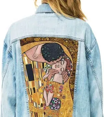 Una mujer lleva una chaqueta vaquera con una pintura de un hombre y una mujer besándose en la espalda.