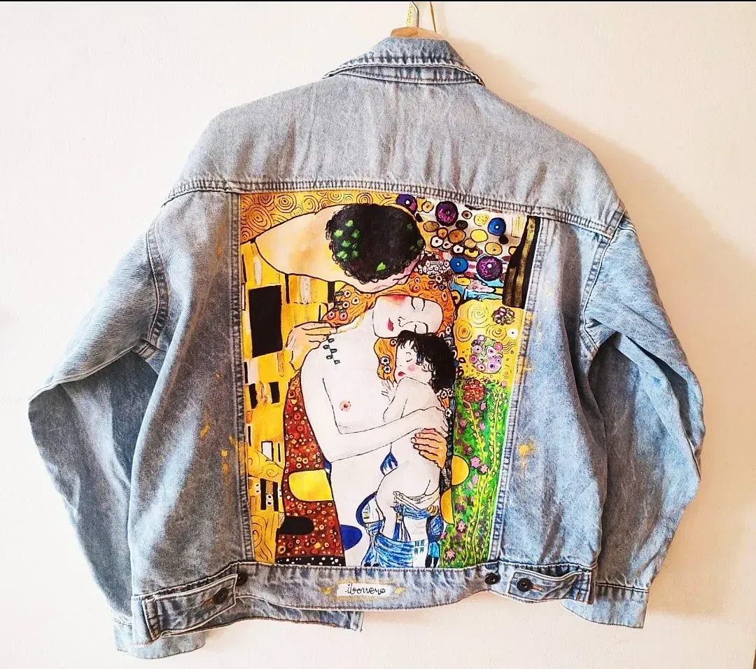 Una chaqueta vaquera con una pintura del beso en la espalda.