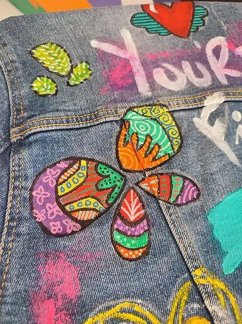 Un primer plano de una chaqueta vaquera con diseños coloridos.