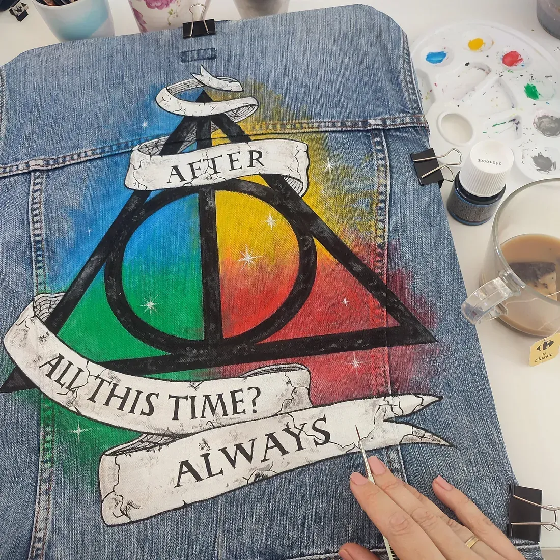 Una persona sostiene una obra de arte que dice: después de todo este tiempo siempre