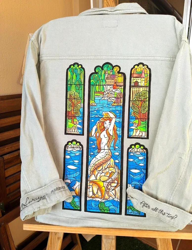 Una chaqueta blanca con un dibujo de una sirena.