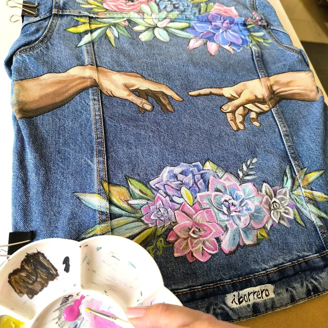Una persona está pintando un cuadro en una chaqueta vaquera.