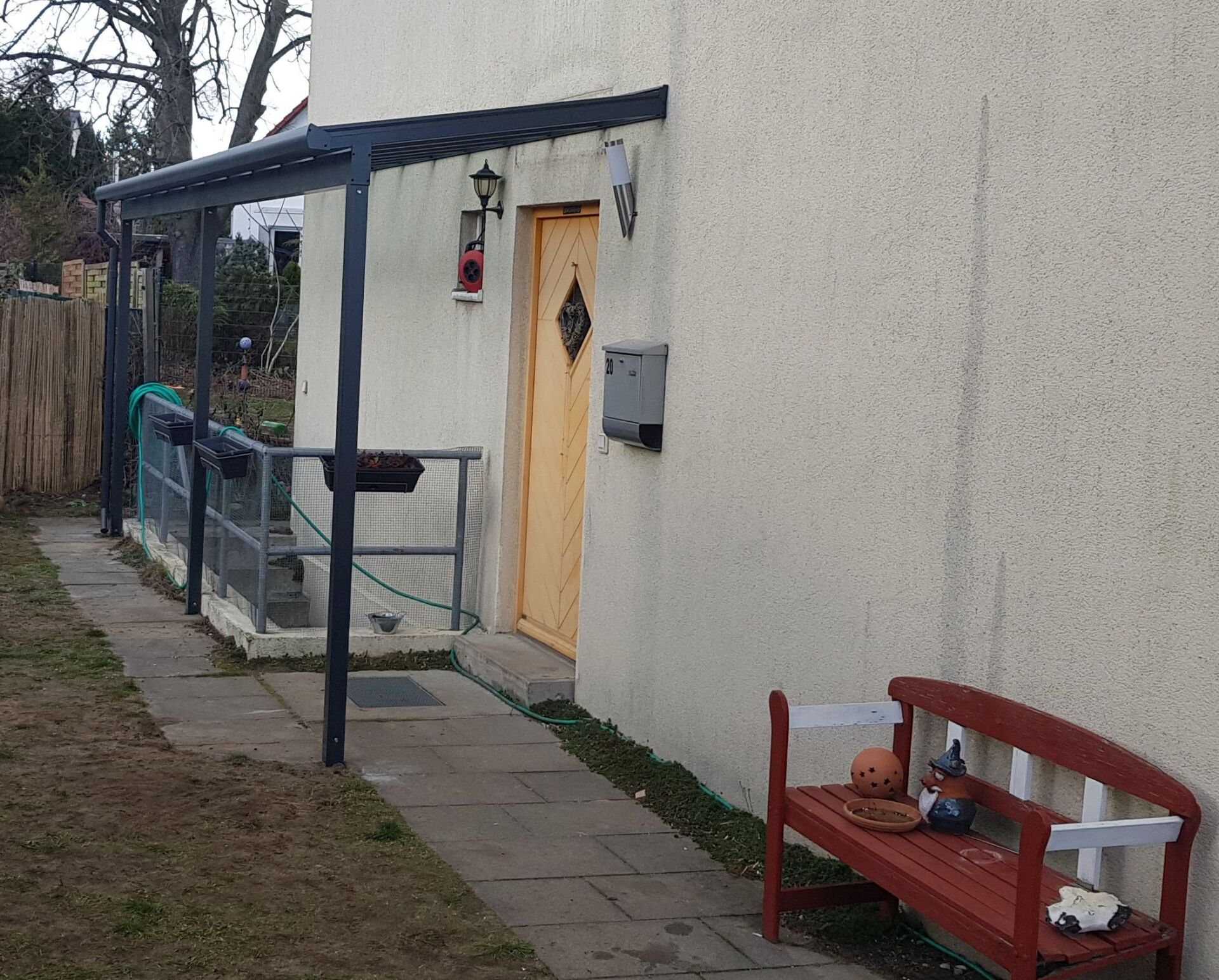 Ein weißes Haus mit einer roten Bank davor