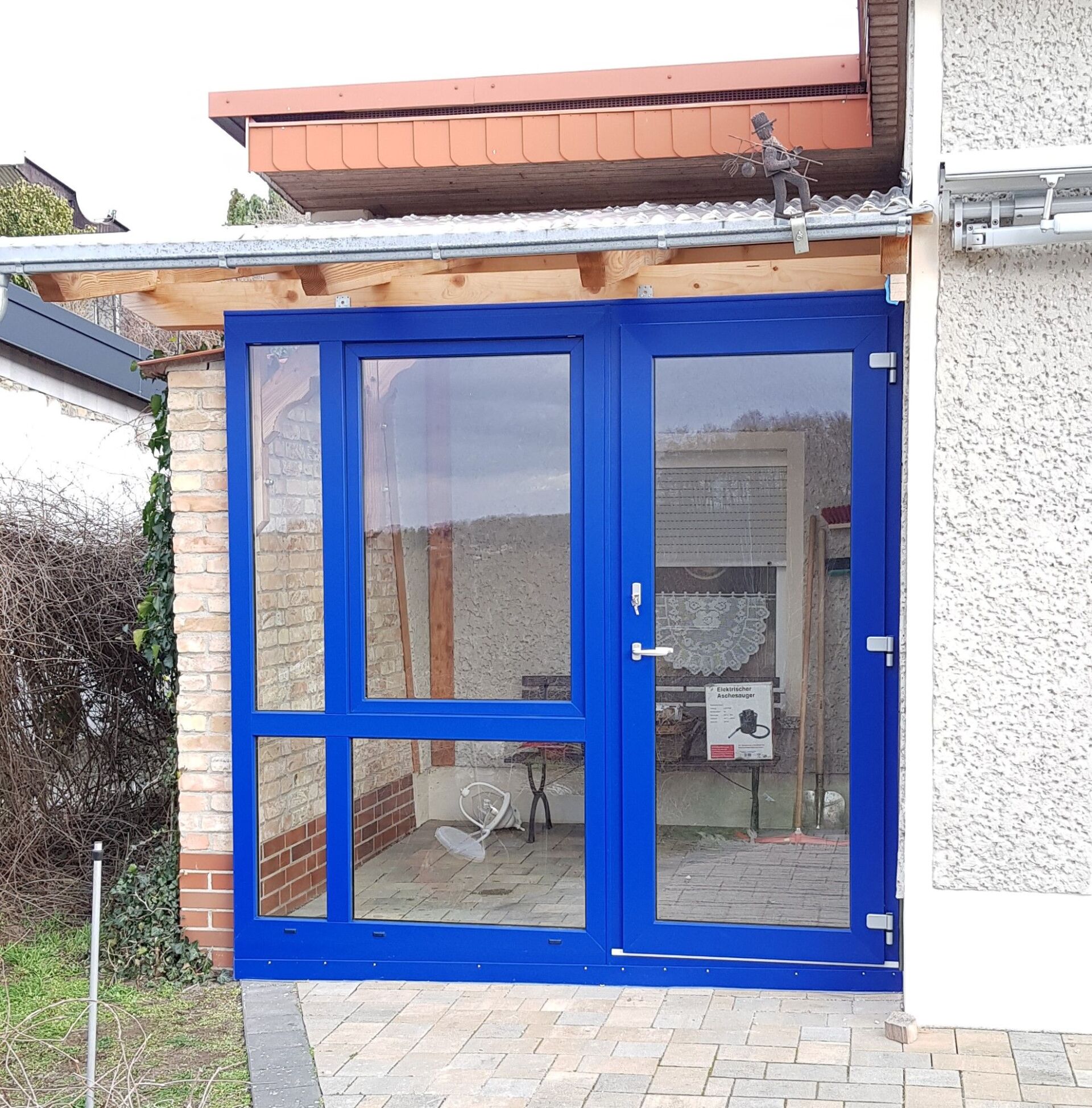 Eine blaue Tür mit einer Backsteinmauer dahinter