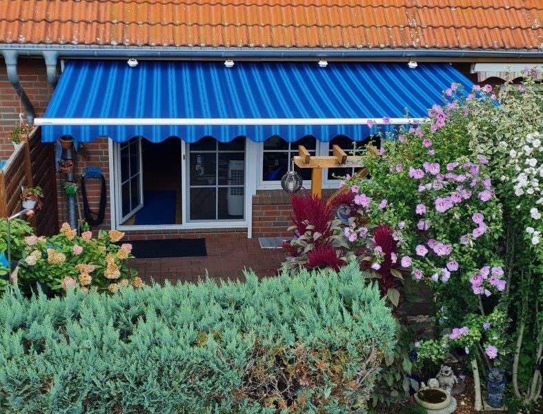 Ein Haus mit einer blauen Markise über der Veranda