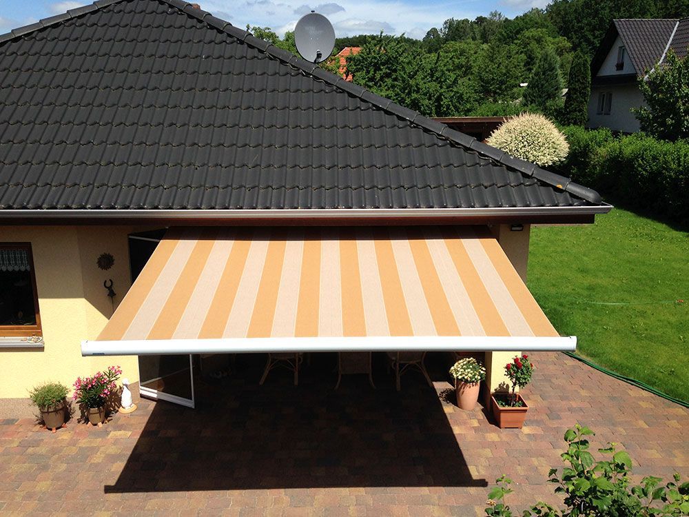 Ein Haus mit einer gestreiften Markise an der Seite