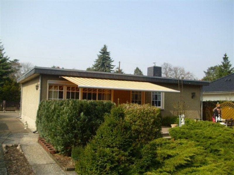 Ein Haus mit einer gelben Markise auf der Veranda