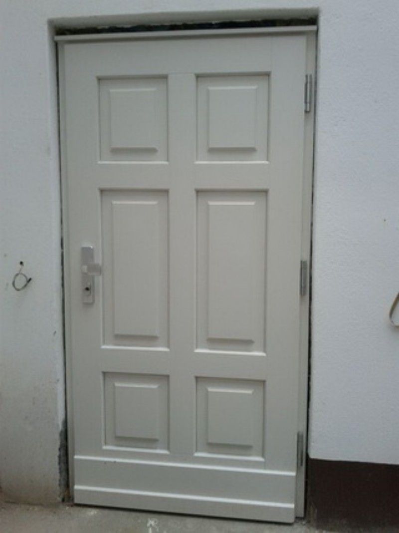 Eine weiße Tür steht an einer weißen Wand.