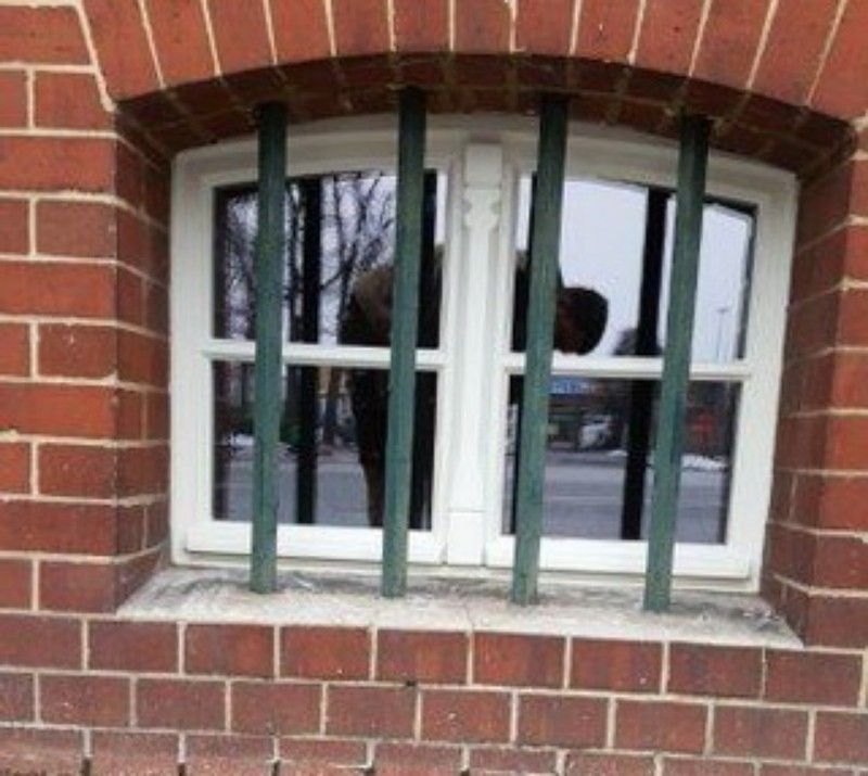Ein Backsteingebäude mit einem vergitterten Fenster