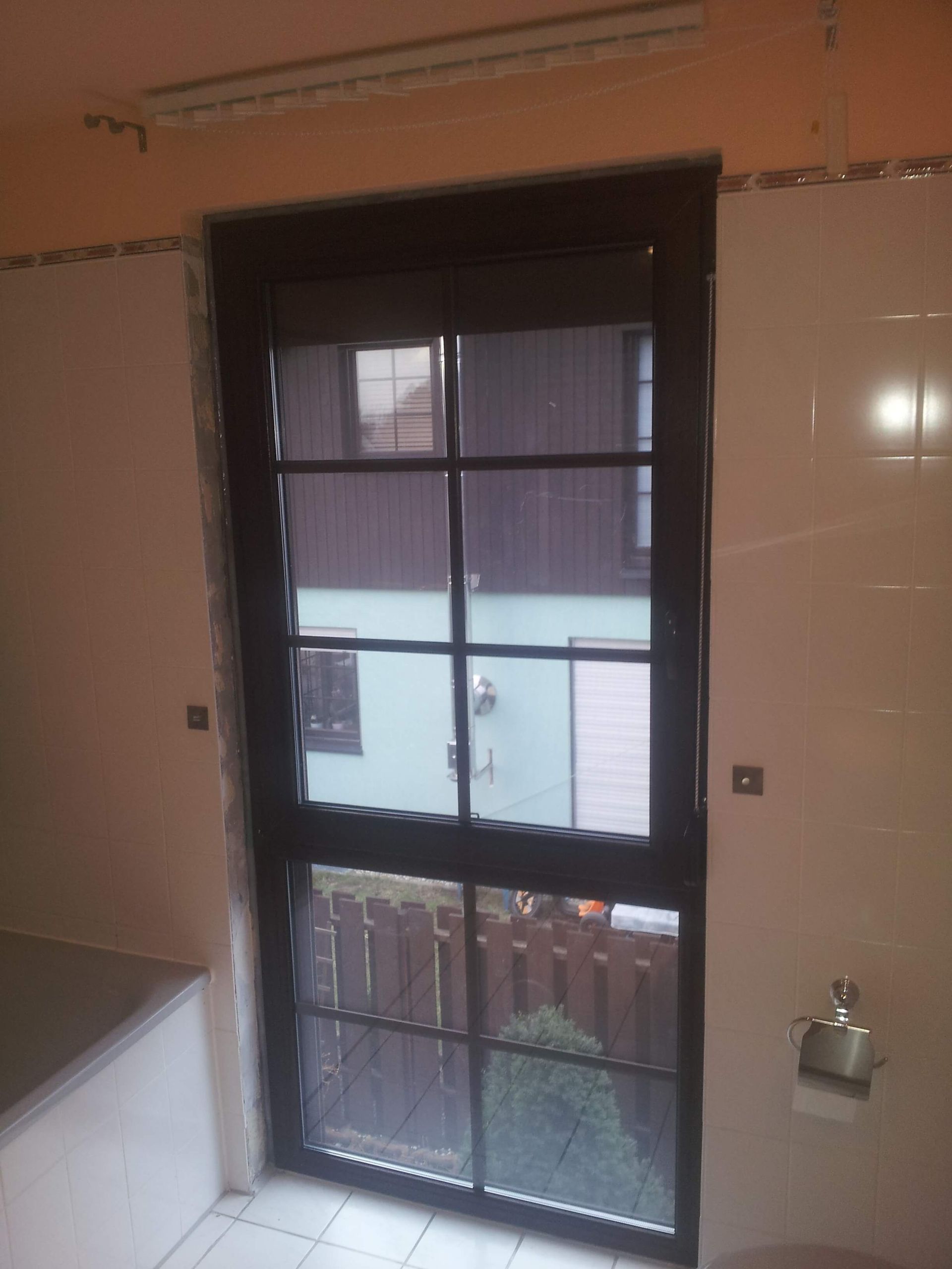 Ein Badezimmer mit großem Fenster und Badewanne