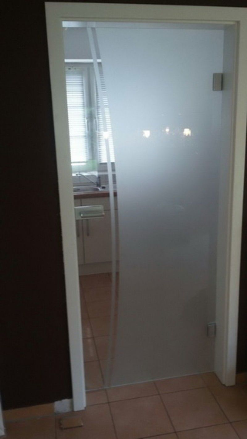 In einem Haus steht eine Glastür zu einer Küche offen.