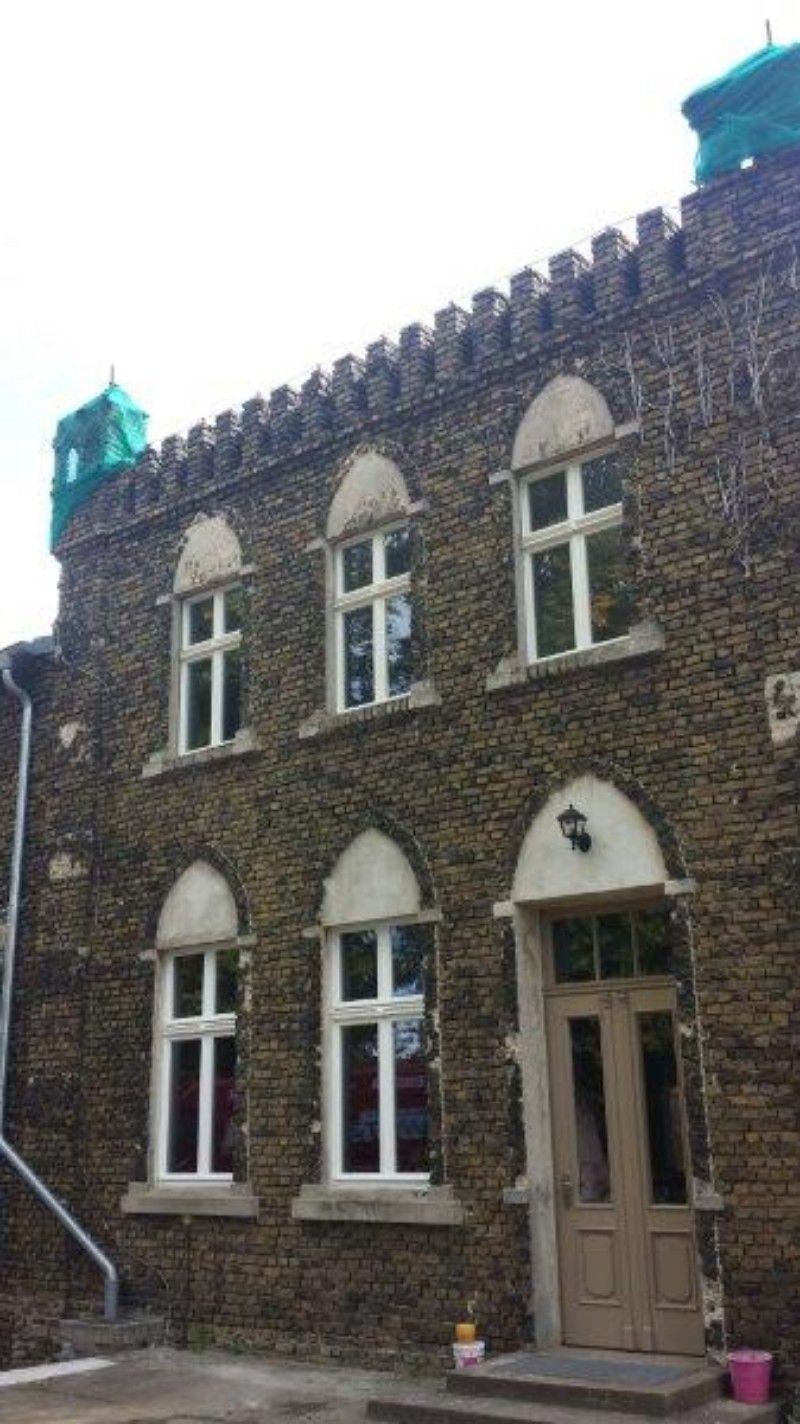 Ein großes Backsteingebäude mit Bogenfenstern und einer Tür