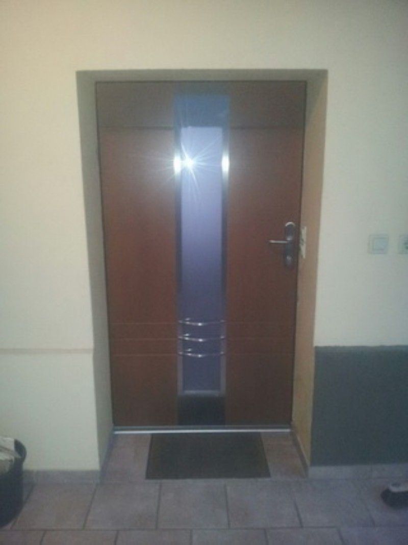 Eine Holztür mit einer schwarzen Matte davor