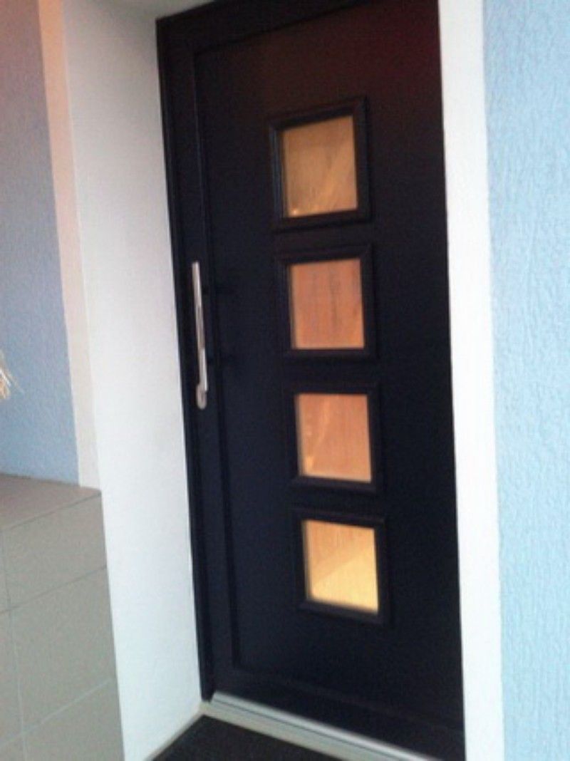 Eine schwarze Tür mit vier quadratischen Fenstern darauf