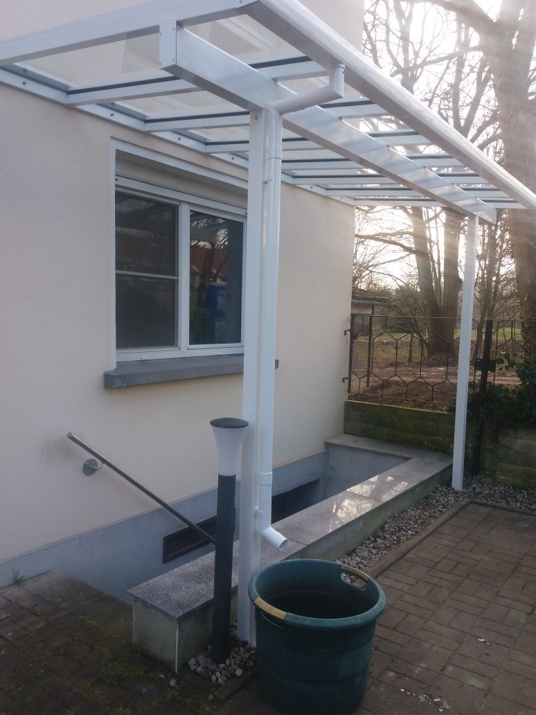 Ein weißes Haus mit einem grünen Topf davor